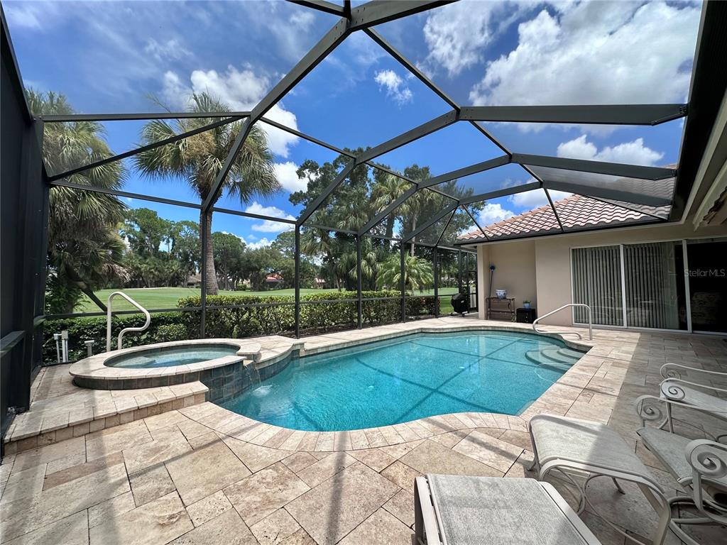 A living room with a fireplace, coffered ceiling, and sliding glass doors leading to a patio — 403 LANSBROOK DRIVE, VENICE, FL