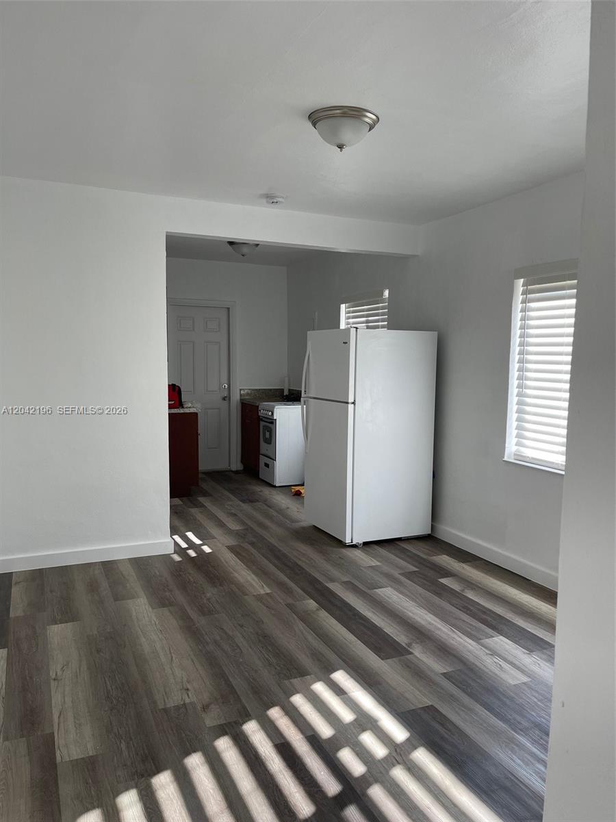 A kitchen area features white walls, wood-look vinyl flooring, and a white refrigerator — 430 SW 6th Ave # 8, Miami FL 33130, MIAMI, FL