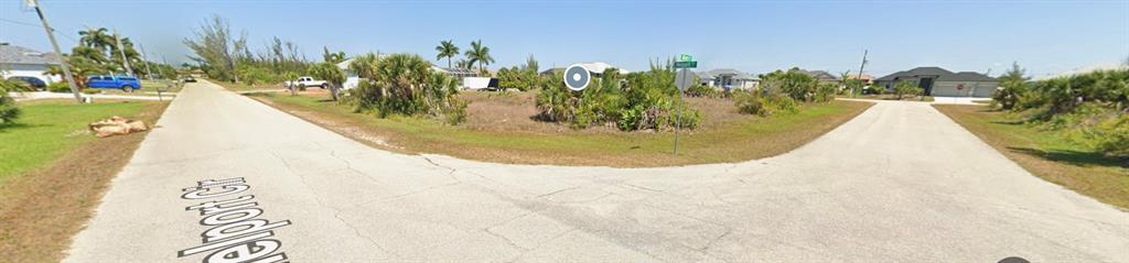 A street-level view shows a vacant, brush-covered corner lot at a residential intersection — 15835 MELPORT CIRCLE, PORT CHARLOTTE, FL