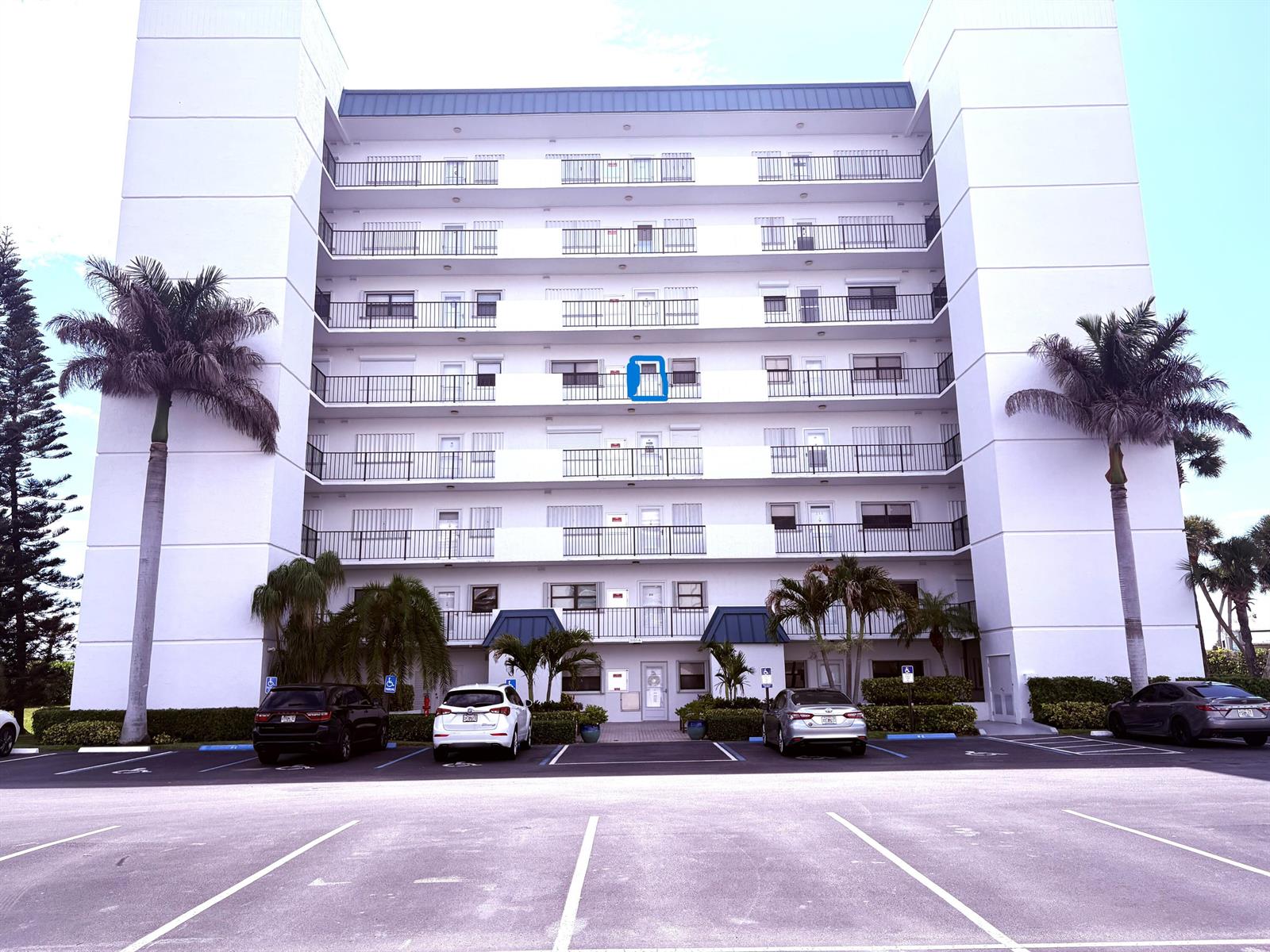 Exterior view of a multi-story white apartment building with balconies and a parking lot — 5151 N Highway A1a # 513, Fort Pierce FL 34949, FORT PIERCE, FL