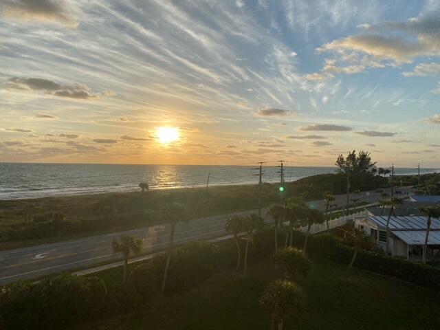 An elevated view of a sunset over the ocean, a coastal road, and palm trees — 5151 N Highway A1a # 513, Fort Pierce FL 34949, FORT PIERCE, FL