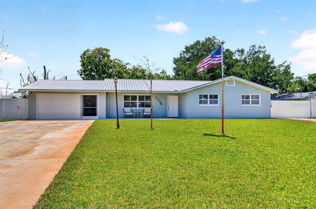 A single-story house with light blue siding, a metal roof, and a front lawn — 2334 CITRUS AVENUE, SOUTH DAYTONA, FL