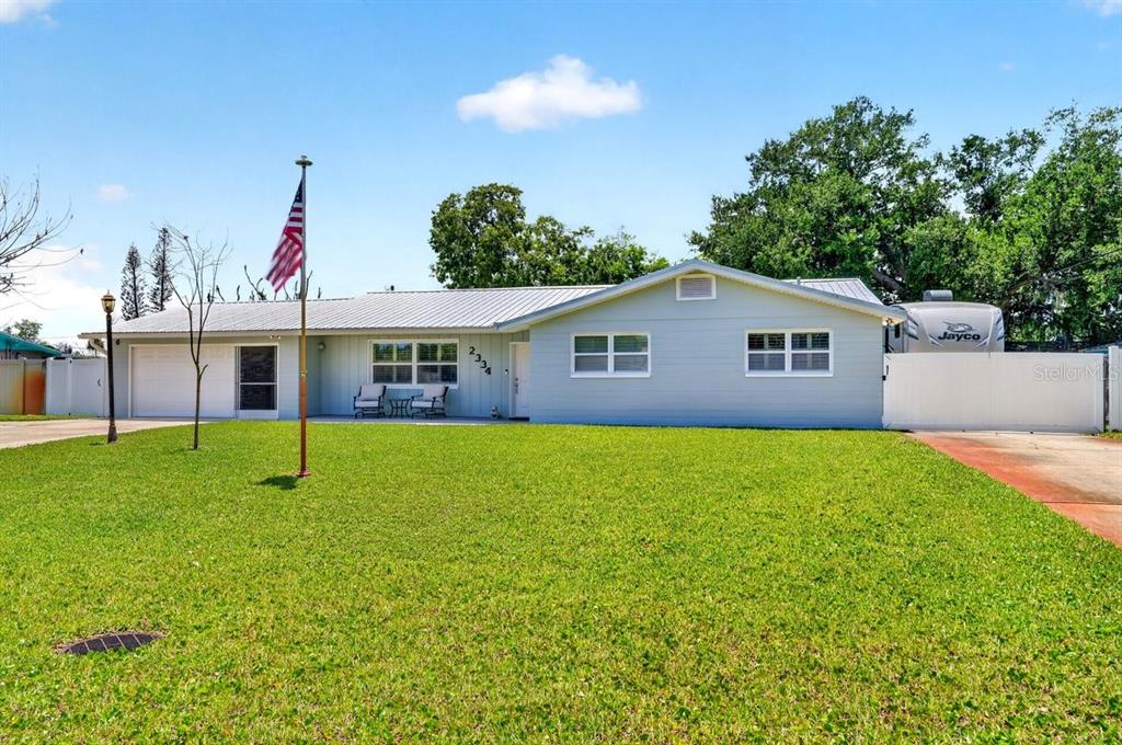 A single-story house with light blue siding, a metal roof, and a front lawn — 2334 CITRUS AVENUE, SOUTH DAYTONA, FL