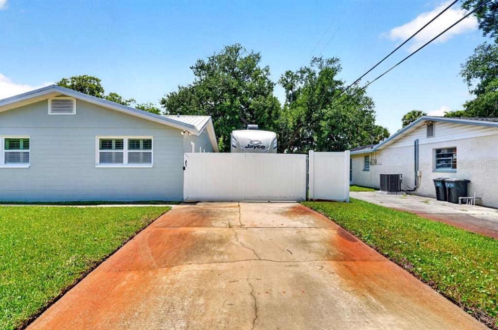 A concrete driveway leads to a white fence between two single-story houses — 2334 CITRUS AVENUE, SOUTH DAYTONA, FL