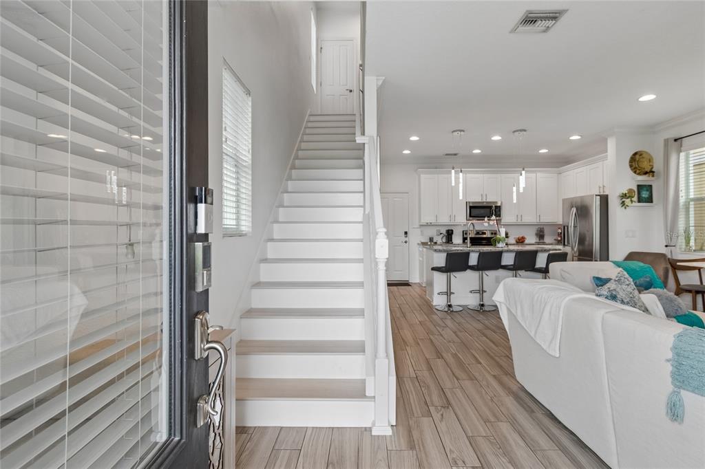 A kitchen features white cabinets, granite countertops, a stainless steel microwave, and a black stove — 3441 BUMELIA LANE, NEW PORT RICHEY, FL
