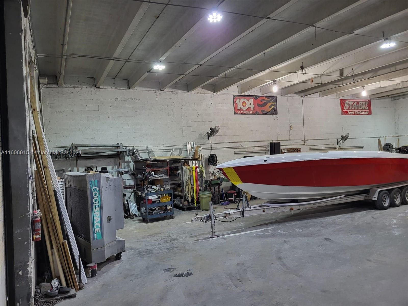 A large industrial warehouse space features a red and white boat on a trailer — 2157 NW 23rd Ave, Miami FL 33142, MIAMI, FL