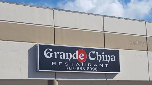 A rectangular sign for Grande China Restaurant is mounted on a beige exterior building wall — State Road PR-3 KM 28.0, RIO GRANDE, PR