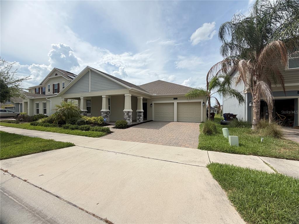 A single-story house with a stone-accented porch, a two-car garage, and a paved driveway — 4921 LOTTA COURT, ST CLOUD, FL