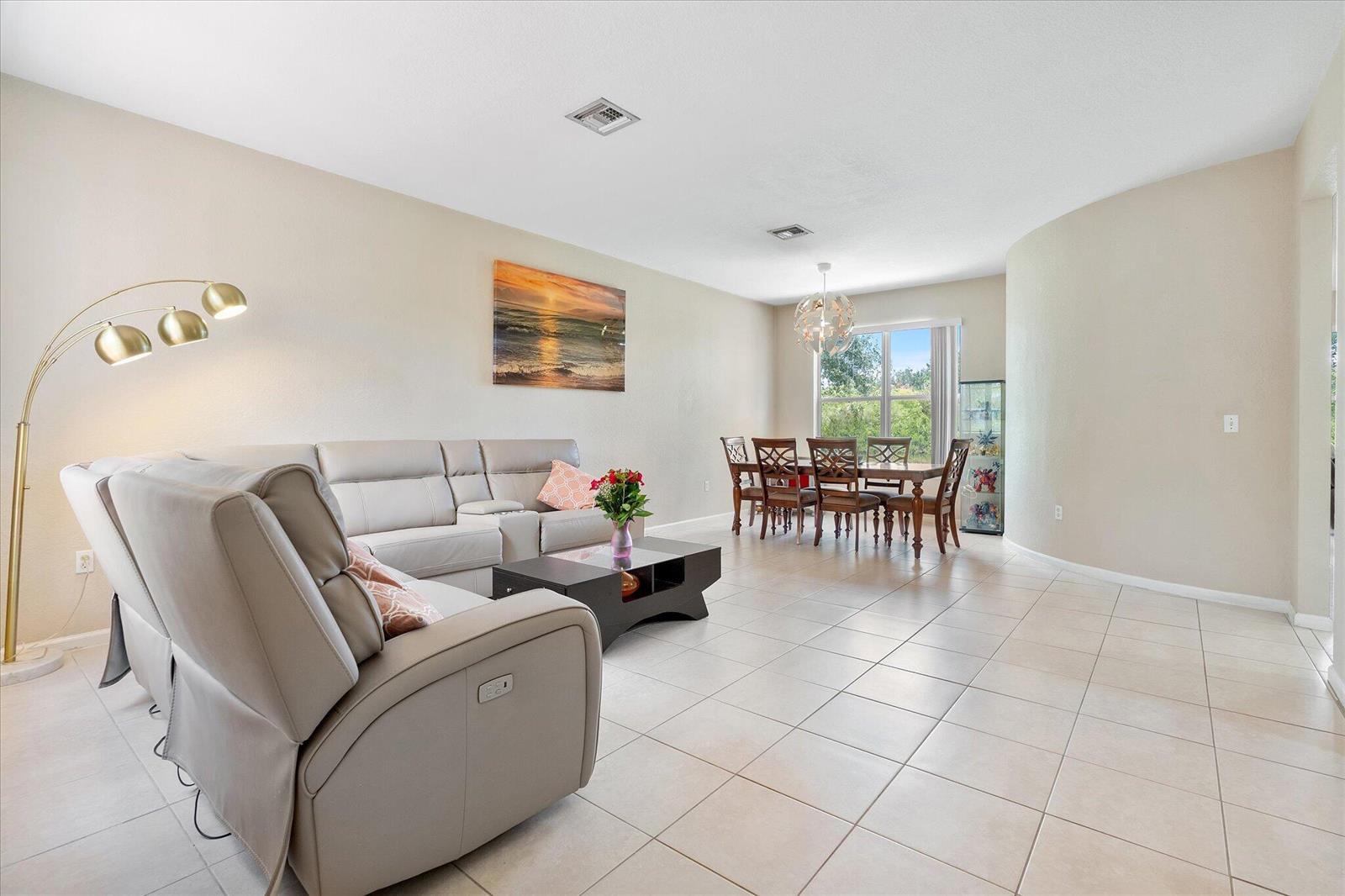 A living room with a light-colored sofa and a dining area with tile flooring — 16385 SW 27th Street, Miramar FL 33027, MIRAMAR, FL