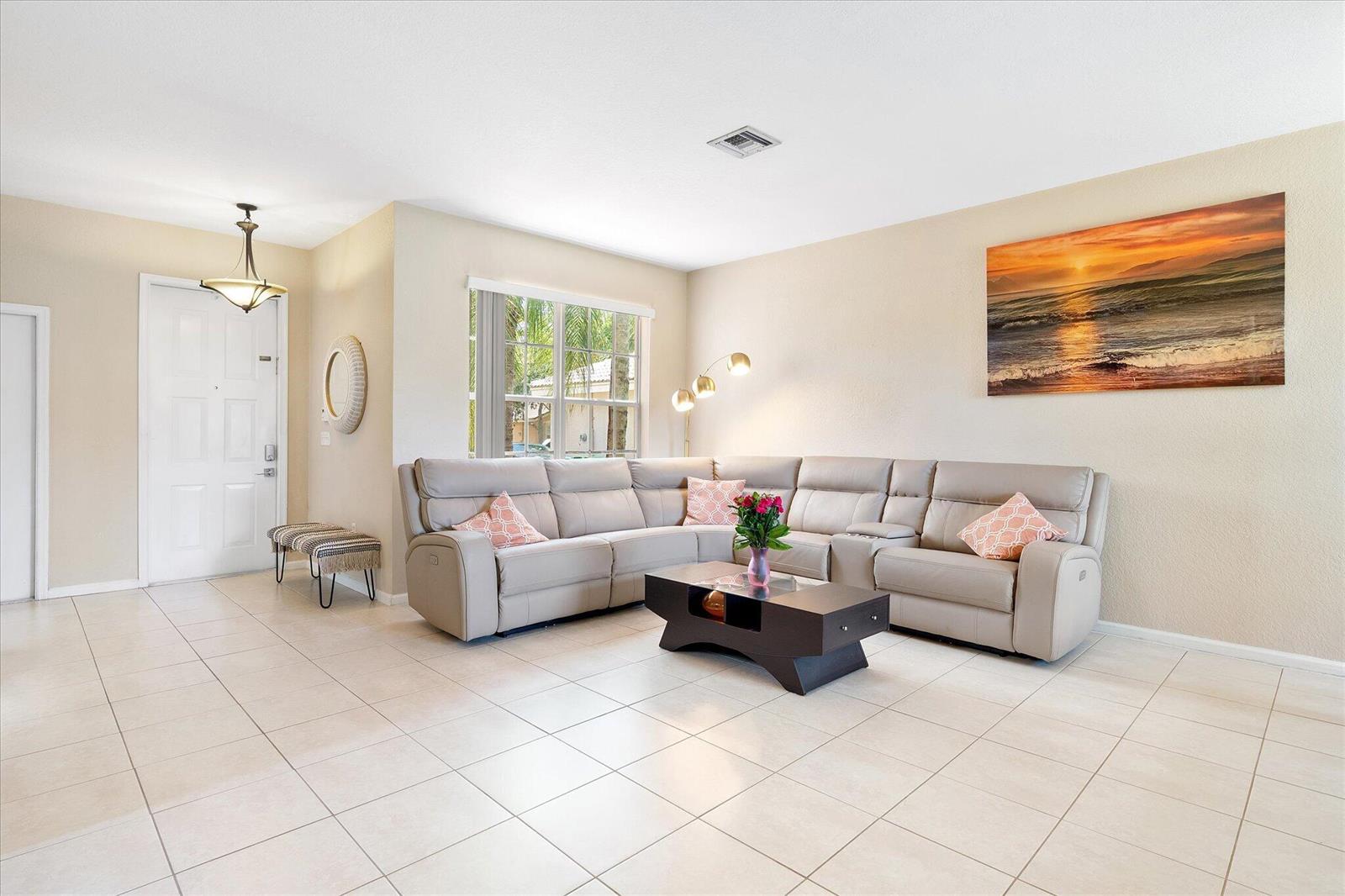 A living room features a large beige sectional sofa, a coffee table, and tile flooring — 16385 SW 27th Street, Miramar FL 33027, MIRAMAR, FL