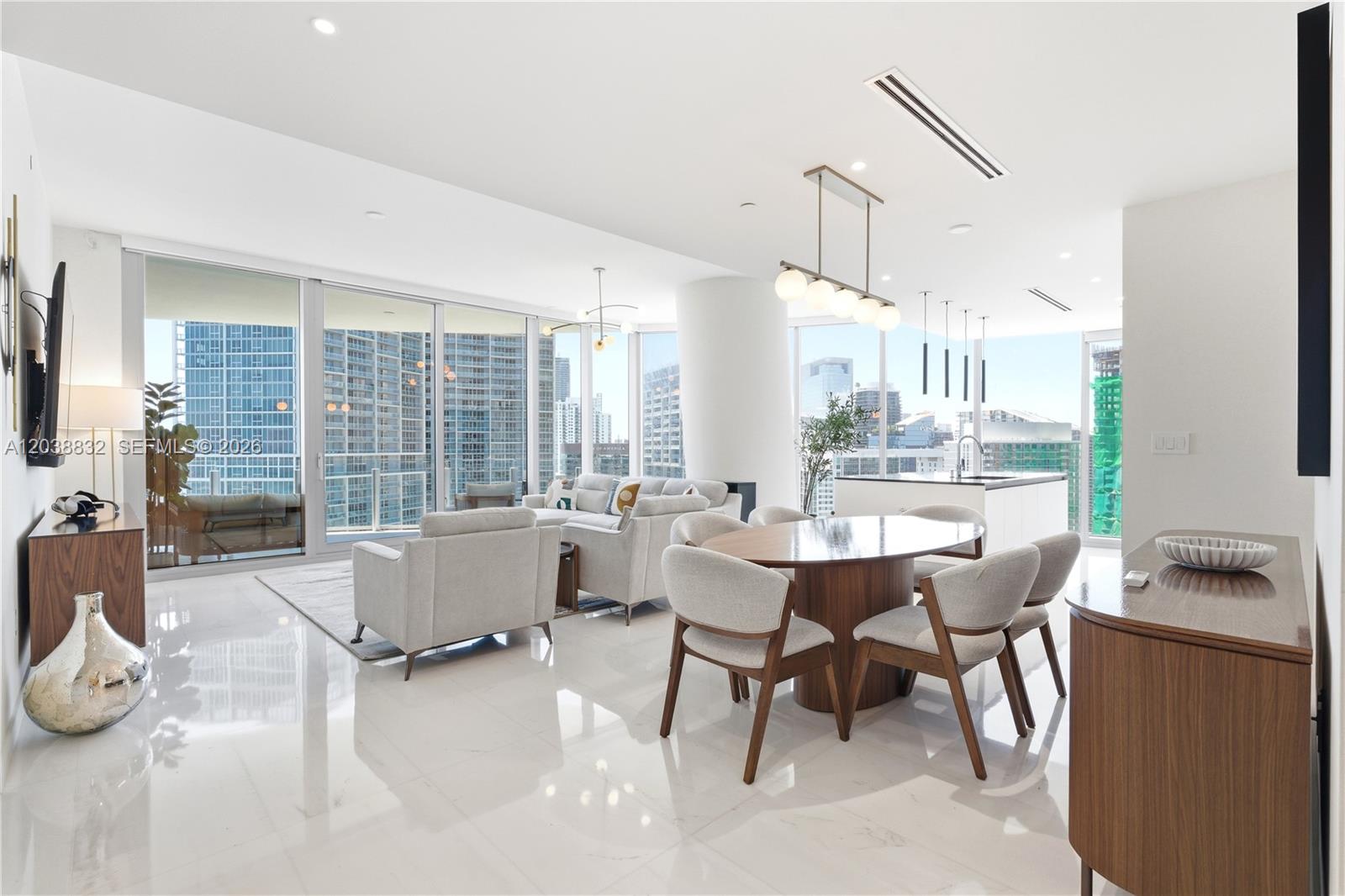 A modern open-concept living and dining area with floor-to-ceiling windows and white marble floors — 300 Biscayne Boulevard Way # 4007W, Miami FL 33131, MIAMI, FL