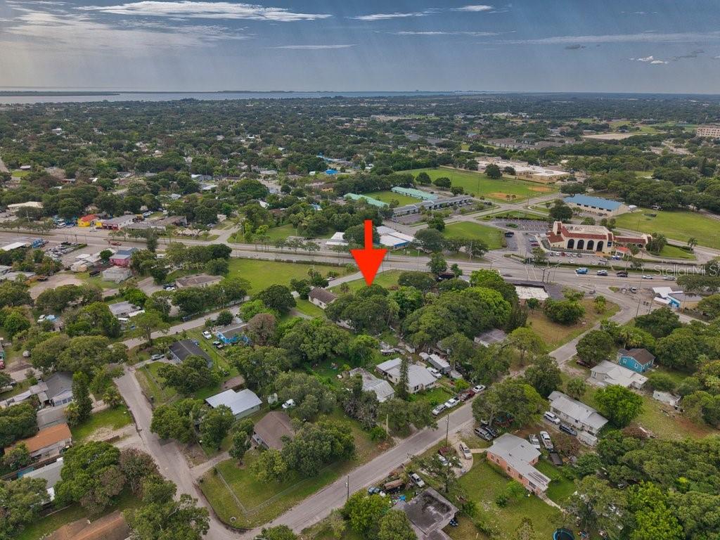 An aerial view shows a residential neighborhood with a red arrow pointing toward a property — 2108 OKEECHOBEE ROAD, FORT PIERCE, FL