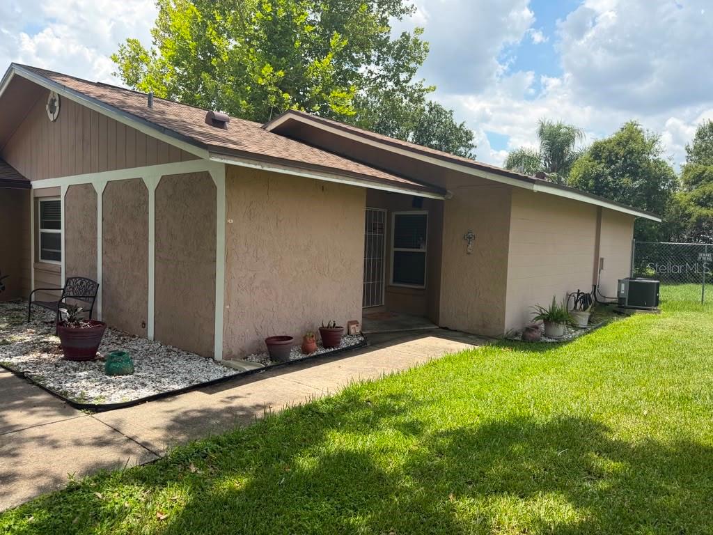 A tan, single-story house with a brown shingled roof and a concrete walkway — 2114 WIND JAMMER COURT, KISSIMMEE, FL
