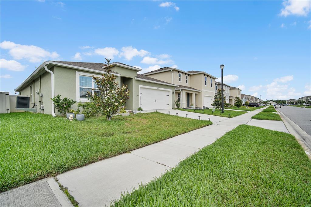 A light green single-story suburban house with a two-car garage and a front lawn — 3201 EASTGROVE TERRACE, SANFORD, FL