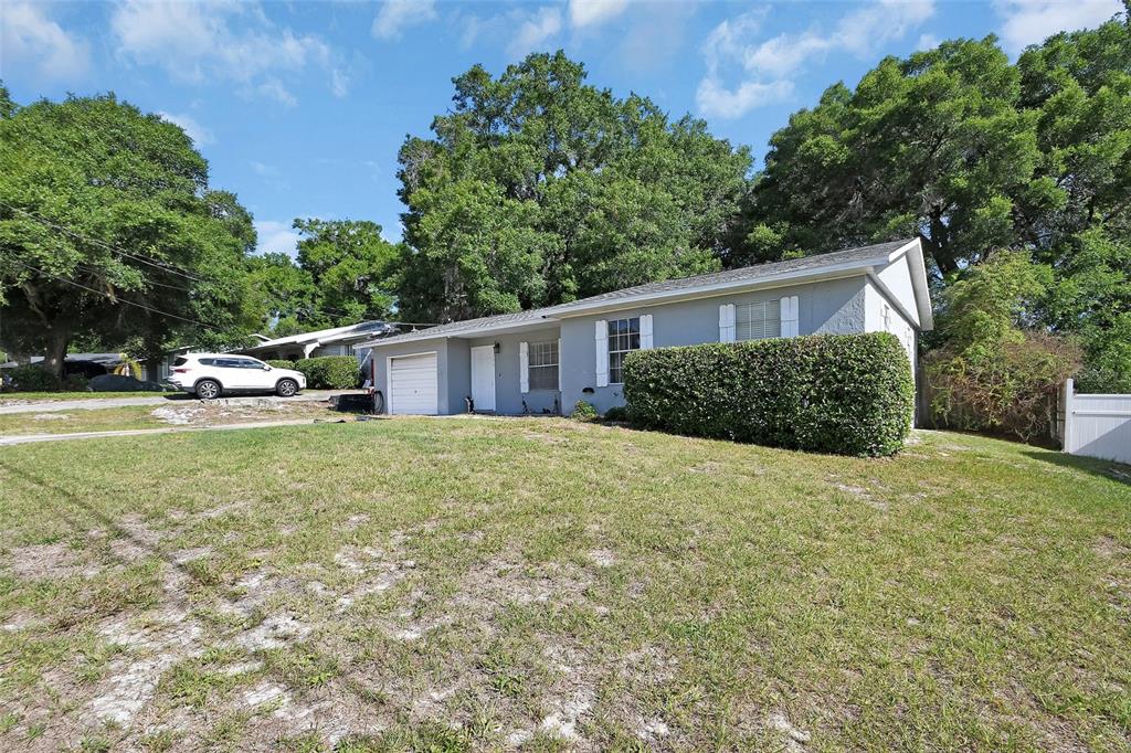 A single-story gray house with a white garage door sits on a grassy lot — 555 SANDY PINES DRIVE, ORANGE CITY, FL