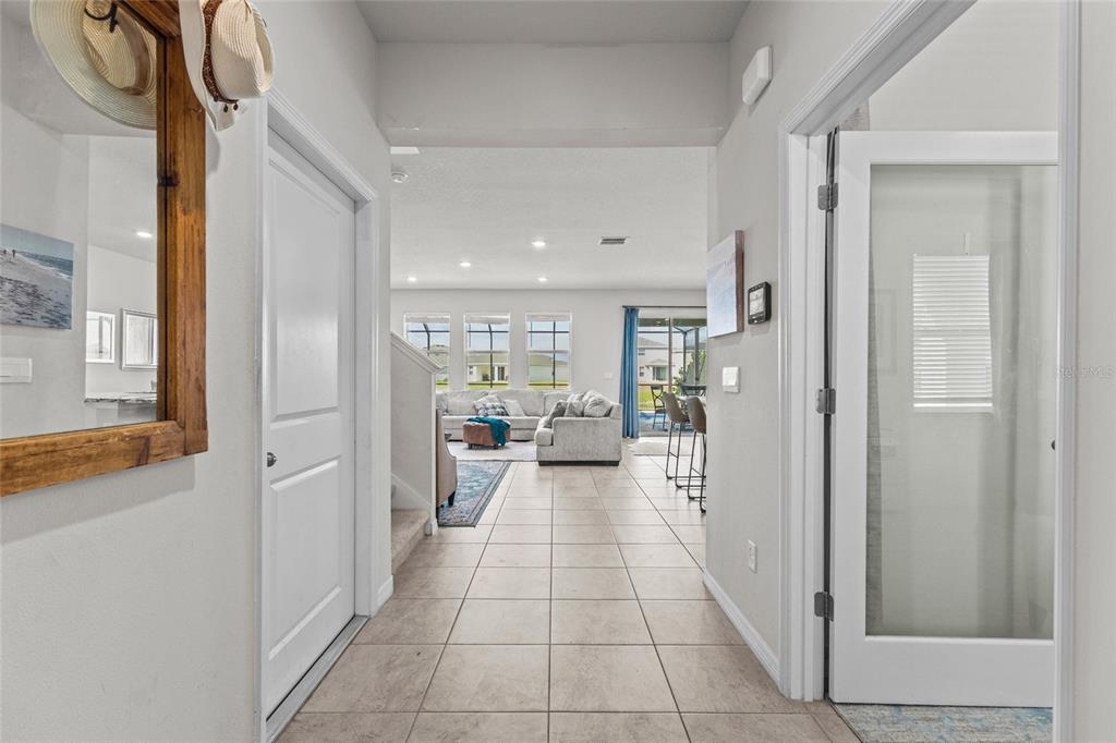 A tiled entryway leads into an open-concept living area with a view of the backyard — 3830 LIVELY CORAL PLACE, BRADENTON, FL