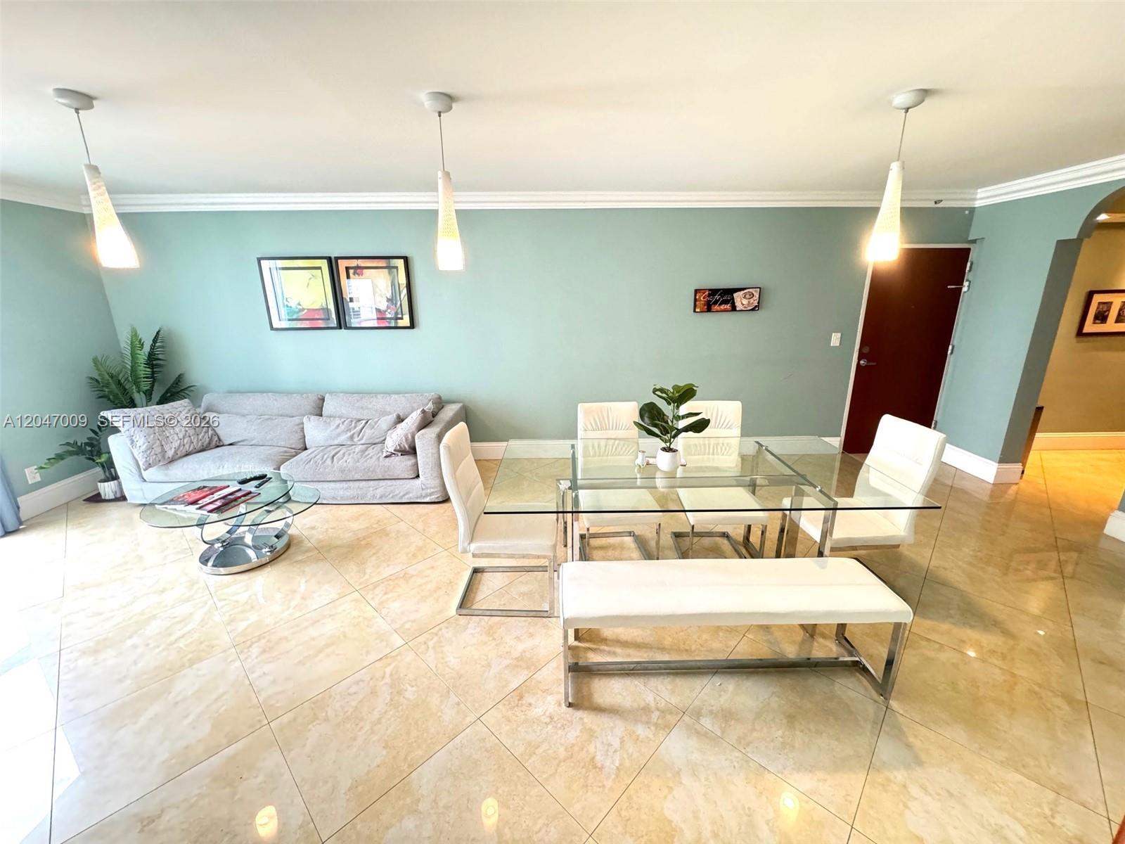 A living and dining area features light green walls, tile flooring, and modern furniture — 3901 S Ocean Dr # 7O, Hollywood FL 33019, HOLLYWOOD, FL