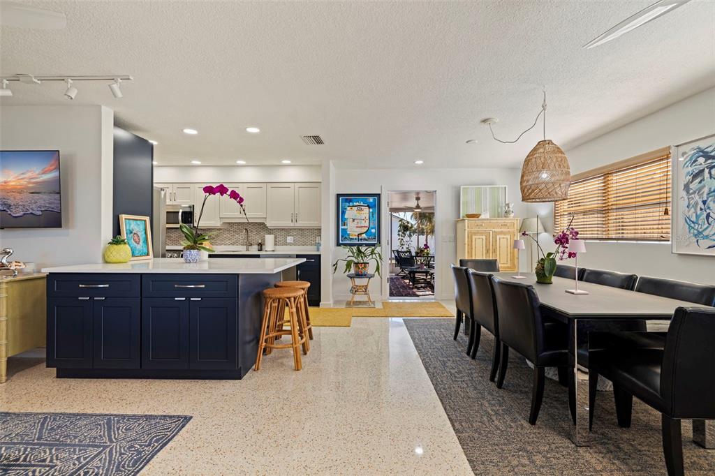 A kitchen with a dark blue island and dining area featuring a long table — 3038 58TH STREET S, GULFPORT, FL