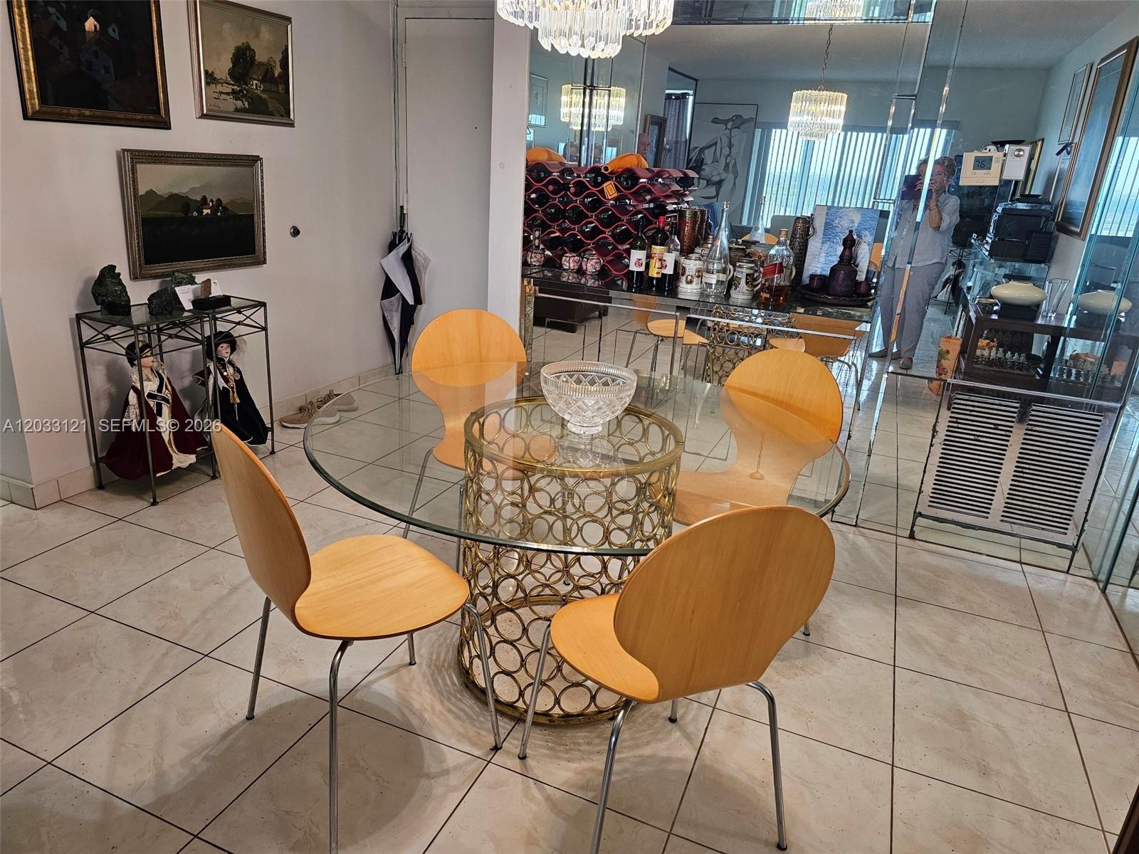 A dining room features a glass-topped table with a gold circular base and four chairs — 3850 Washington St # 1011, Hollywood FL 33021, HOLLYWOOD, FL