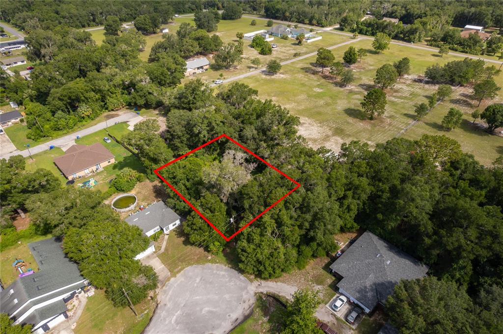 An aerial view shows a wooded residential lot outlined in red near a cul-de-sac — 1431 S MONTGOMERY STREET, DELAND, FL