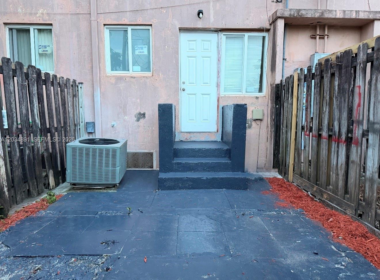 A small patio area features a painted concrete floor, steps to a door, and fencing — 8447 NW 4th Ave # 8447, Miami FL 33150, MIAMI, FL