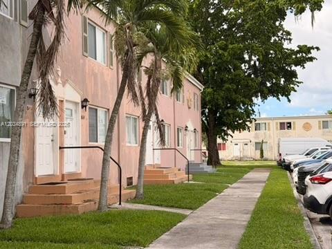 Exterior view of a two-story pink apartment building with palm trees and a sidewalk — 8447 NW 4th Ave # 8447, Miami FL 33150, MIAMI, FL