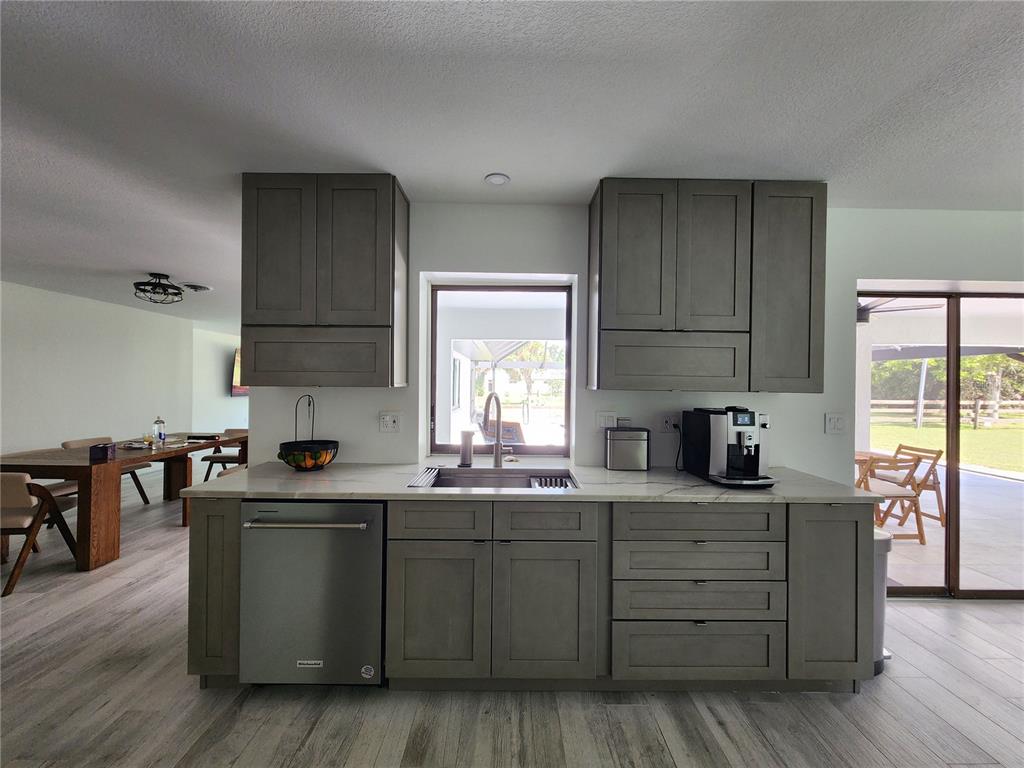 A kitchen features gray shaker cabinets, stainless steel appliances, and a window above the sink — 900 CRESTWOOD ROAD, ENGLEWOOD, FL