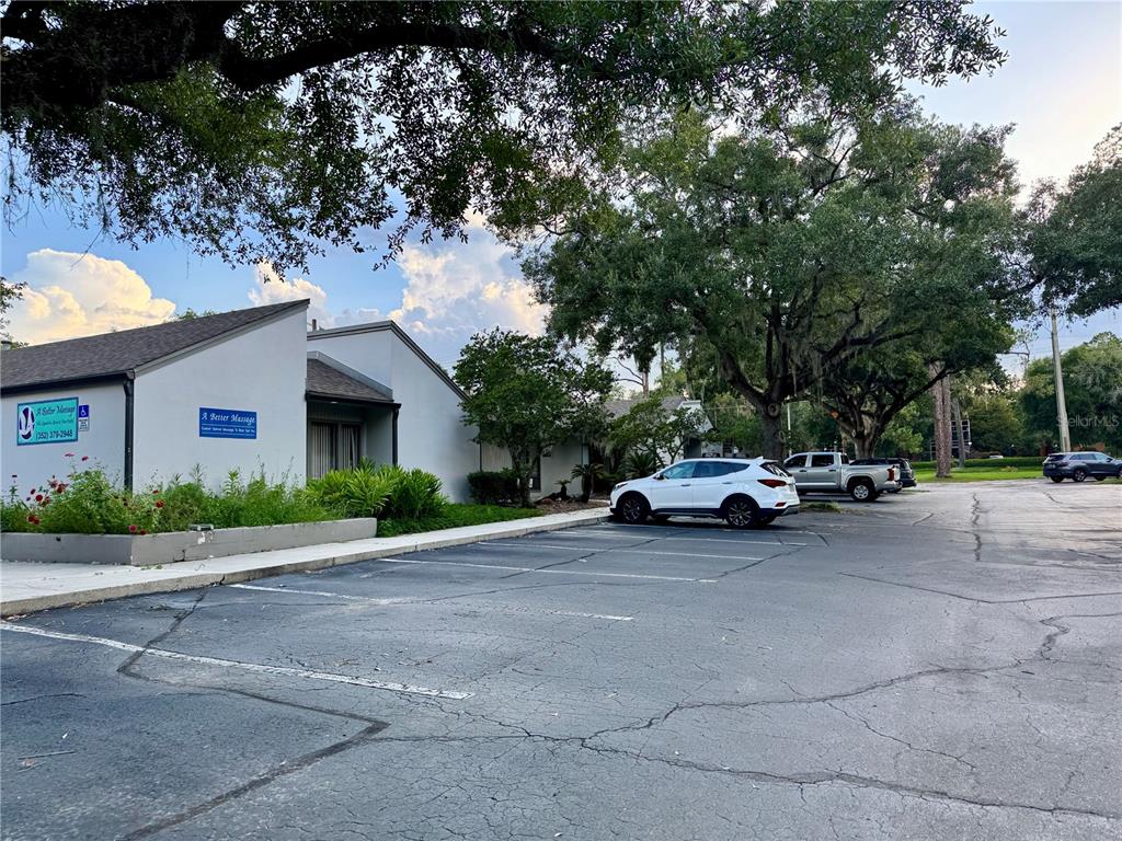 A white commercial building with a parking lot and large trees in front — 2727 NW 43RD STREET, GAINESVILLE, FL