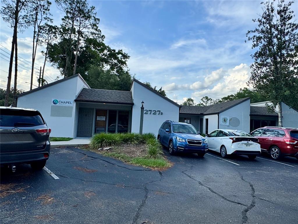 A single-story commercial building with a gray facade and parking lot in front — 2727 NW 43RD STREET, GAINESVILLE, FL