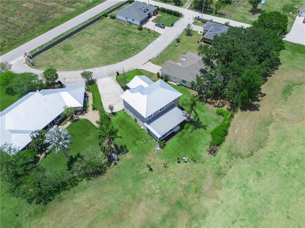 An aerial view shows a two-story house with a metal roof and a large backyard — 2910 FAIRWAY, BOWLING GREEN, FL