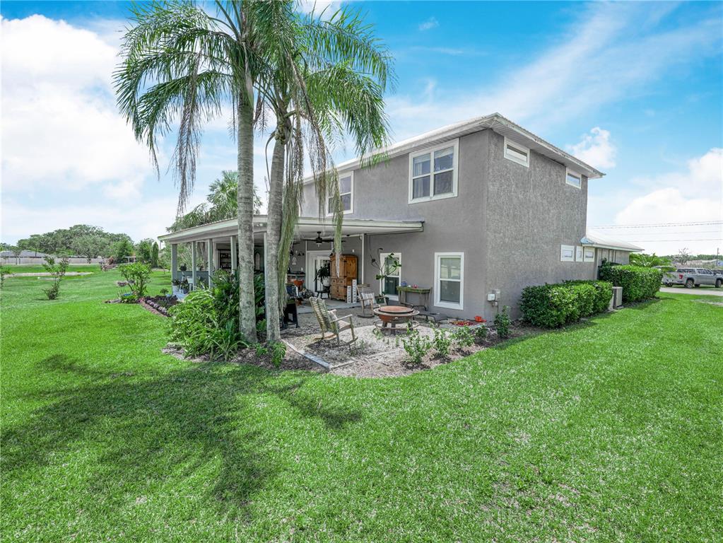 A two-story gray house with a covered patio, palm trees, and a grassy backyard — 2910 FAIRWAY, BOWLING GREEN, FL