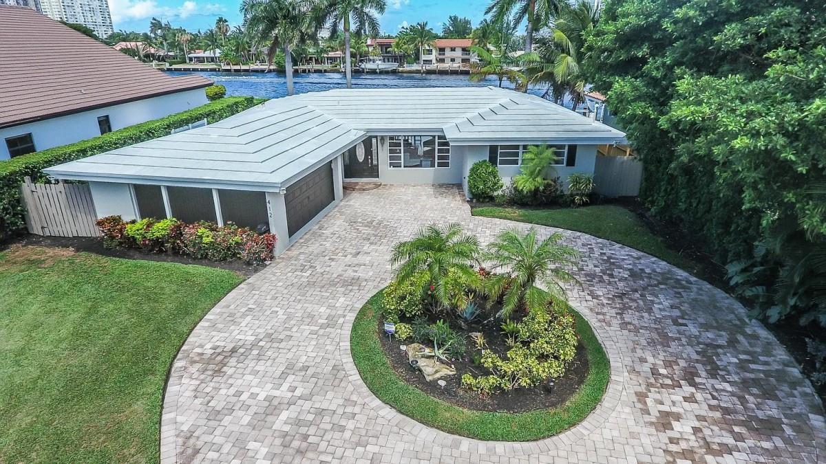 An aerial view of a single-story house with a circular paver driveway and waterfront backyard — 412 SE 28th Avenue, Pompano Beach FL 33062, POMPANO BEACH, FL