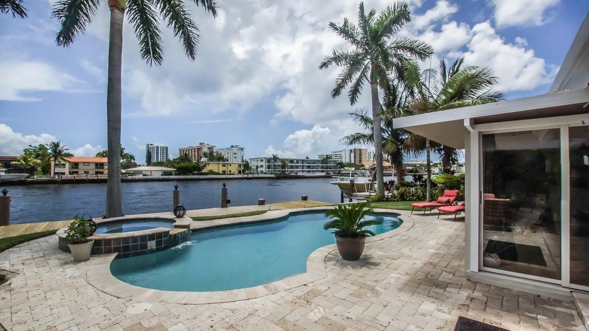 A backyard patio features a swimming pool, hot tub, palm trees, and a waterfront view — 412 SE 28th Avenue, Pompano Beach FL 33062, POMPANO BEACH, FL