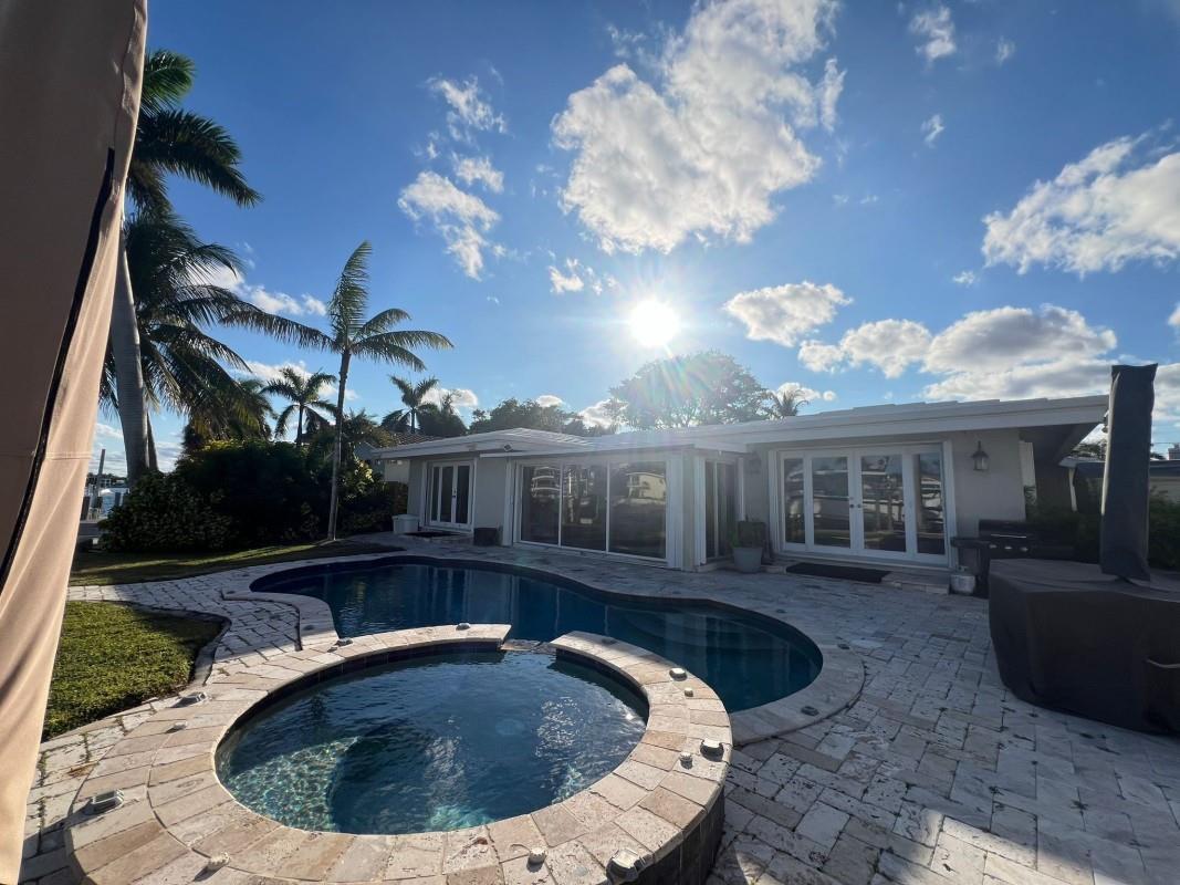 A backyard features a swimming pool, a raised hot tub, and a paved patio area — 412 SE 28th Avenue, Pompano Beach FL 33062, POMPANO BEACH, FL