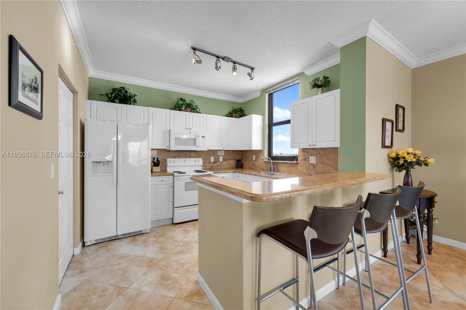 An aerial view of a clover-shaped swimming pool surrounded by lounge chairs and palm trees — 651 Okeechobee Blvd # 1002, West Palm Beach FL 33401, WEST PALM BEACH, FL