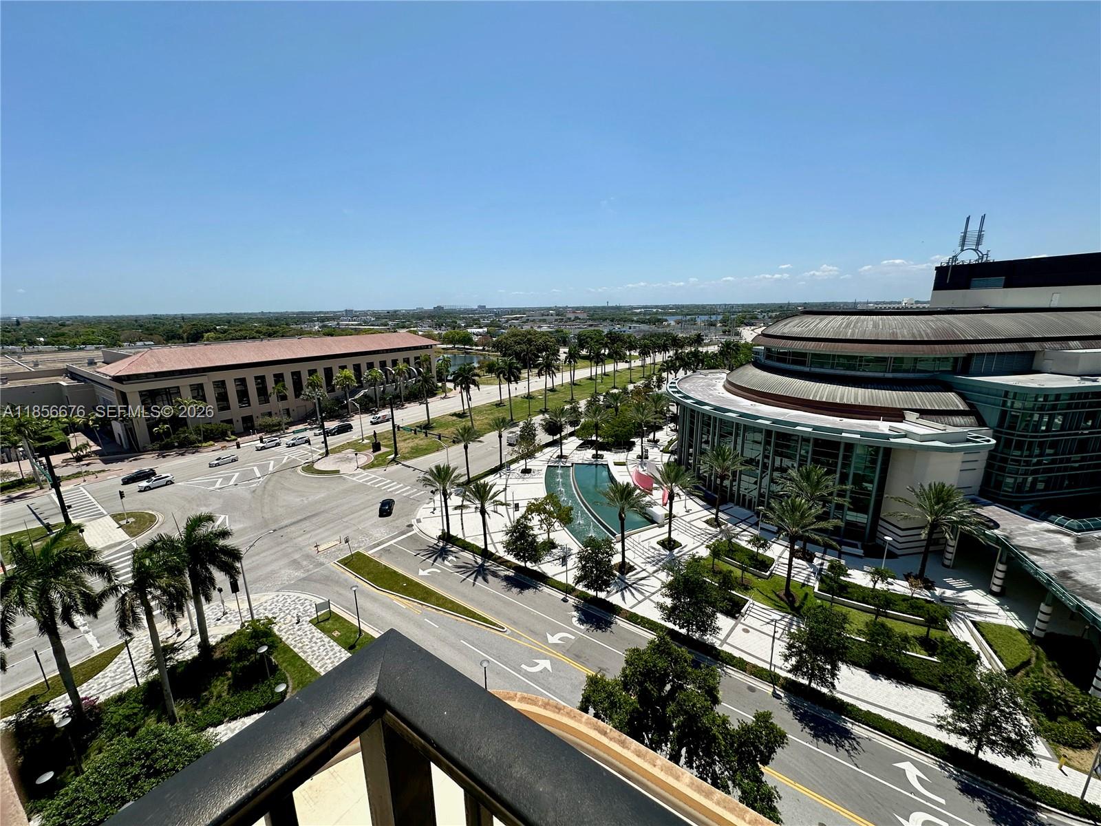 A living room features a white sectional sofa, a dark leather armchair, and a television console — 651 Okeechobee Blvd # 1002, West Palm Beach FL 33401, WEST PALM BEACH, FL