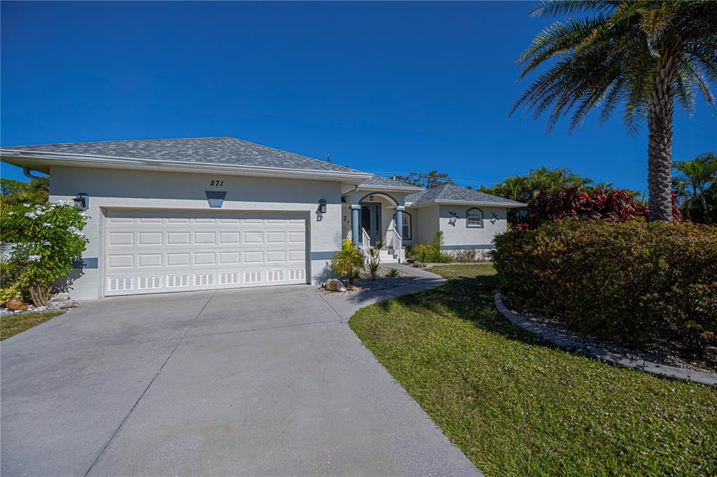 A single-story house with a two-car garage, concrete driveway, and palm tree in the front — 271 ANNAPOLIS LANE, ROTONDA WEST, FL