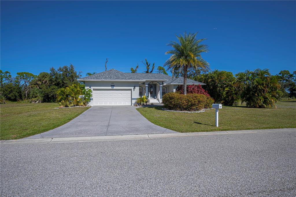 A single-story house with a white garage, gray roof, and palm tree in the yard — 271 ANNAPOLIS LANE, ROTONDA WEST, FL