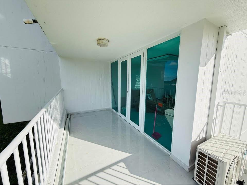 A balcony with white tiled flooring, a white railing, and glass sliding doors — Dos Marinas II DOS MARINAS II, NO. 110, FAJARDO, PR
