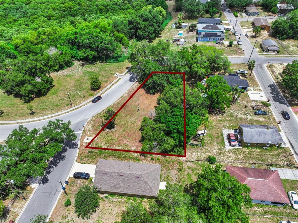 An aerial view shows a vacant, trapezoidal-shaped residential lot outlined in red — 0 LAKESHORE BOULEVARD, HAINES CITY, FL