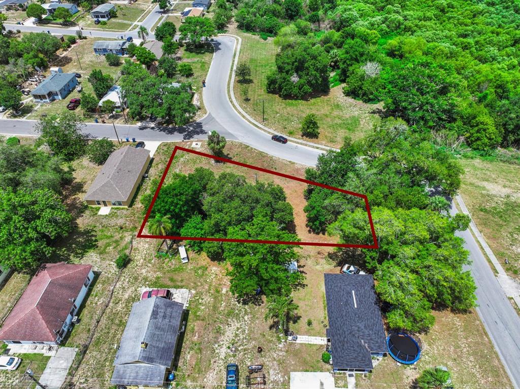 An aerial view shows a vacant, tree-covered lot outlined in red between residential houses — 0 LAKESHORE BOULEVARD, HAINES CITY, FL