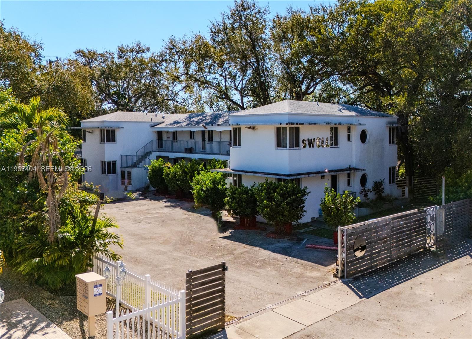 An aerial view of a two-story white apartment building with a gated parking lot — 648 NE 80th St, Miami FL 33138, MIAMI, FL