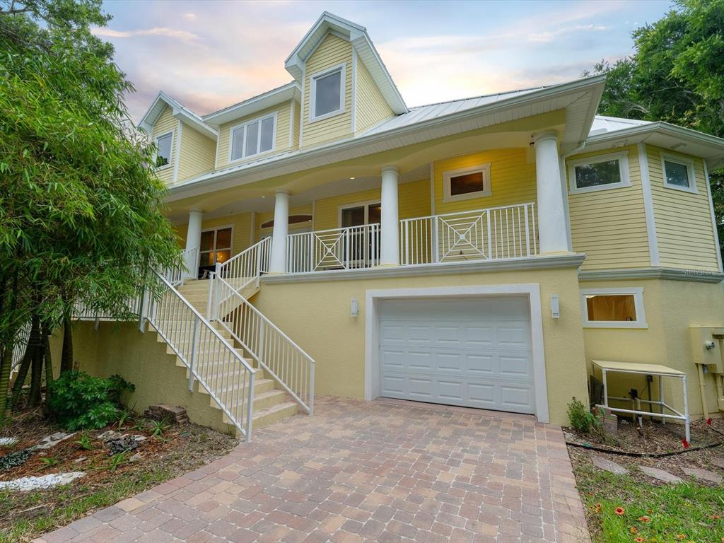 A yellow multi-story house features a screened-in patio, multiple balconies, and a spiral staircase — 110 OCEAN WAY DRIVE, PONCE INLET, FL