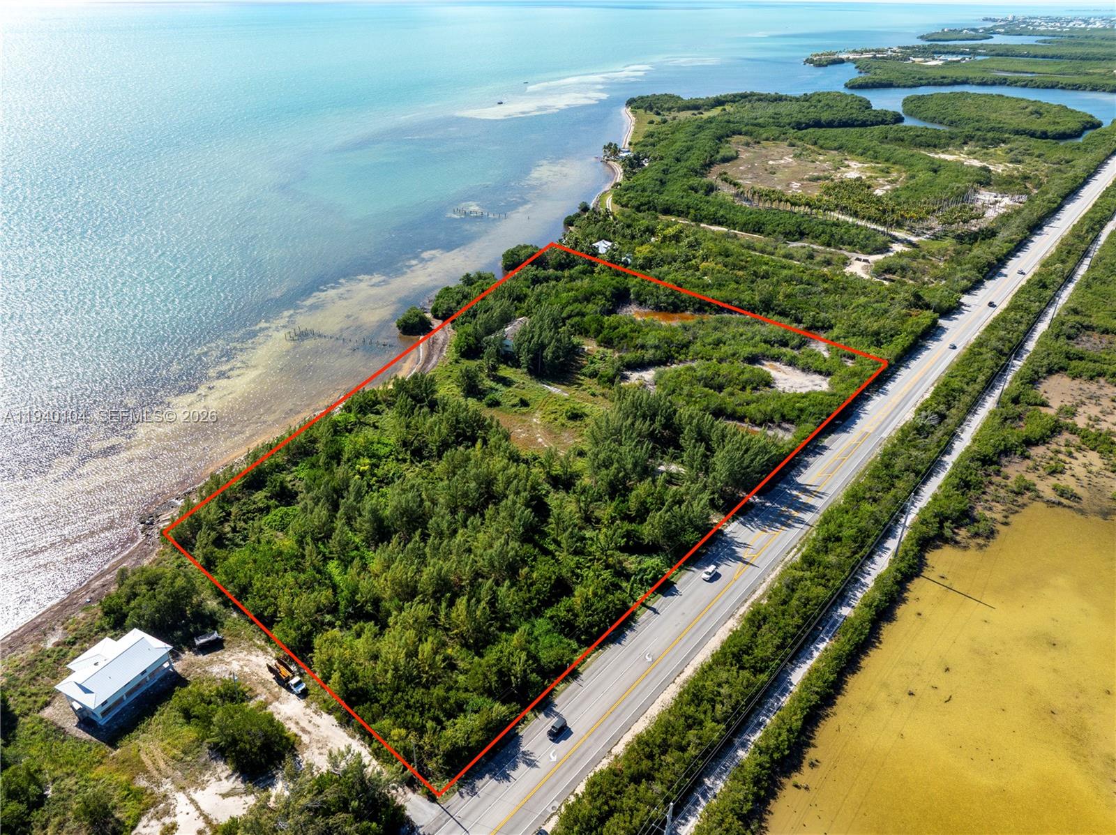 An aerial view shows a rectangular plot of land bordered by a road and water — 57478 Overseas Hwy, Marathon FL 33050, MARATHON, FL