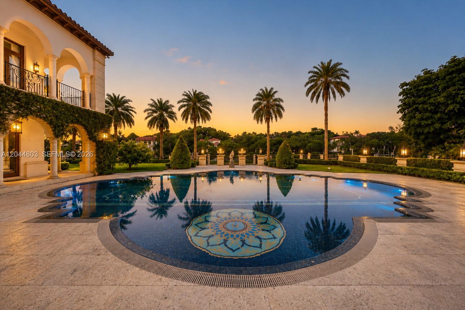 A luxury home exterior features a large swimming pool with a mosaic tile floor design — 150 Edgewater Dr, Coral Gables FL 33133, CORAL GABLES, FL