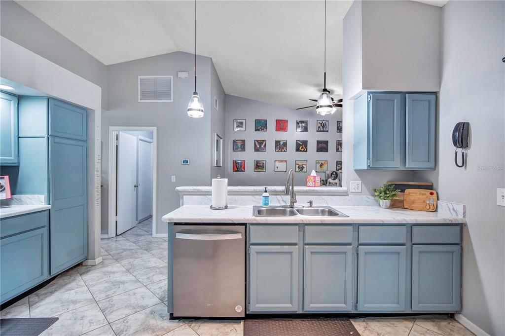 A kitchen features blue cabinets, stainless steel appliances, and a white marble-patterned countertop — 1237 LEATHERWOOD DRIVE, ALTAMONTE SPRINGS, FL