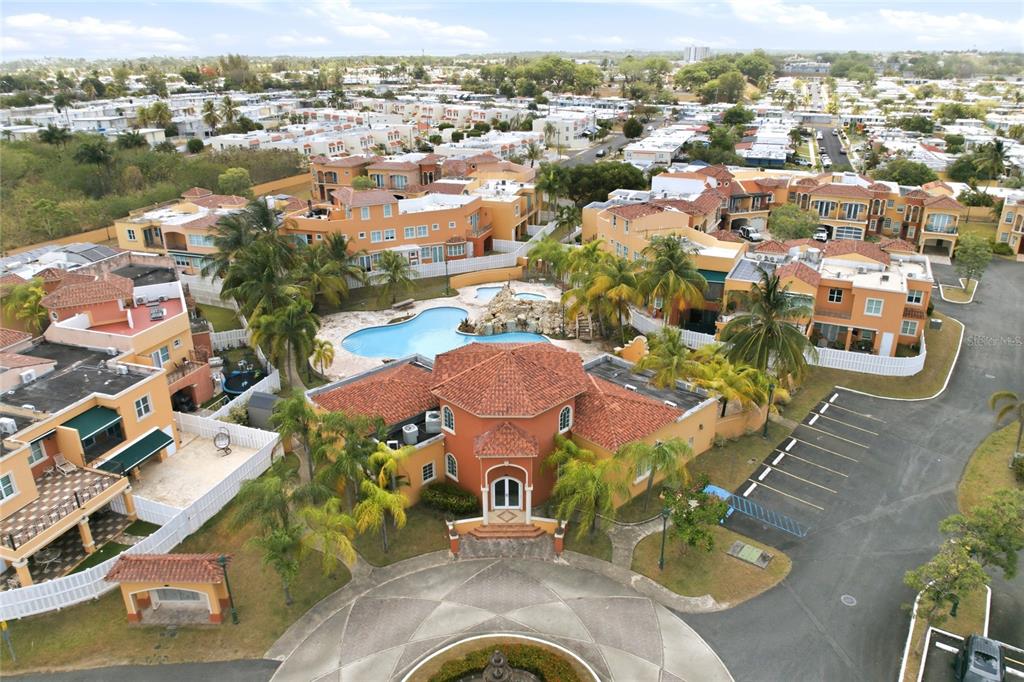 An aerial view shows a community clubhouse with a pool and surrounding residential buildings — E-2 BRIGHTON COUNTRY CLUB, DORADO, PR