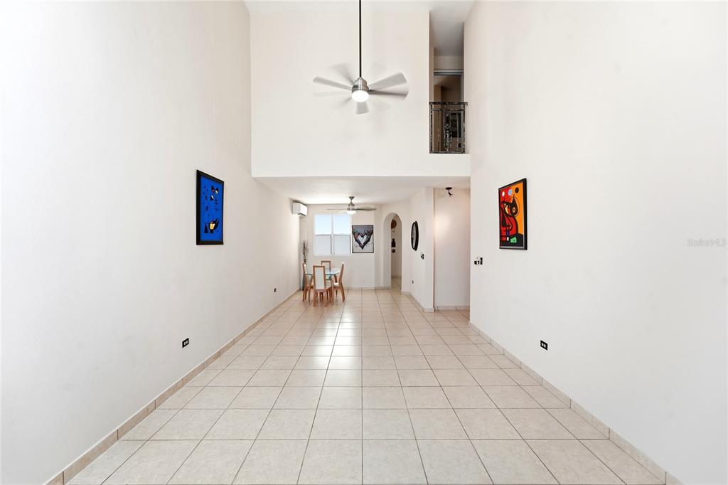 A long, tiled living area features high ceilings, a ceiling fan, and a dining set — E-2 BRIGHTON COUNTRY CLUB, DORADO, PR