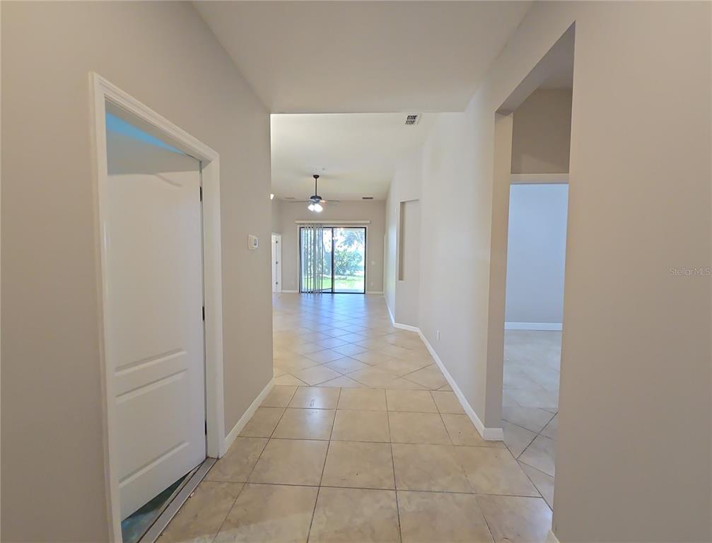 A tiled entryway leads into a living area with a sliding glass door to the outside — 5201 SUNSET CANYON DRIVE, KISSIMMEE, FL