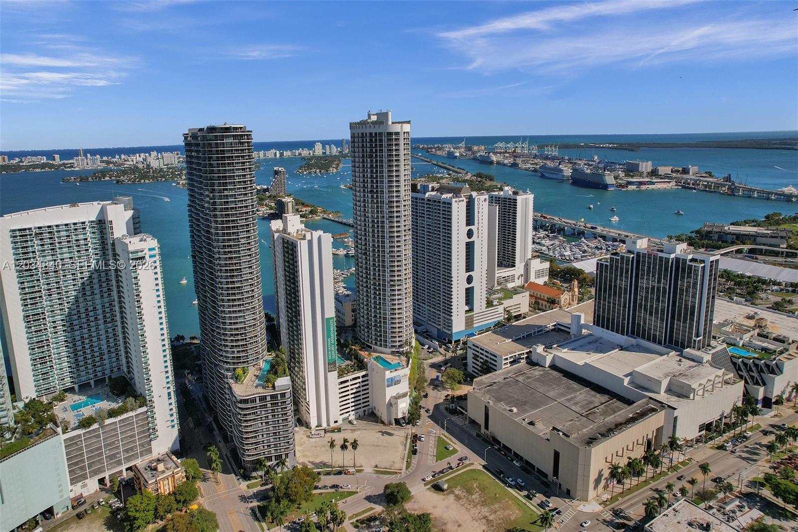 An aerial view of high-rise apartment buildings and a large commercial structure near the water — 1750 N Bayshore Dr # 3802, Miami FL 33132, MIAMI, FL